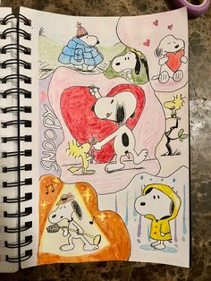 an open notebook with drawings of dogs and people on it, including a dog holding a heart