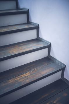 the stairs are painted white and have wood treading on each step, which is also black