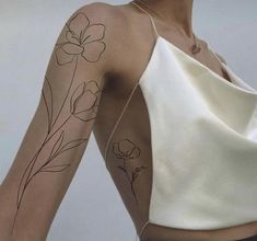 a woman's arm with flowers on it, and the back of her shoulder