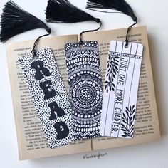 three bookmarks with black tassels on top of an open book, and one has