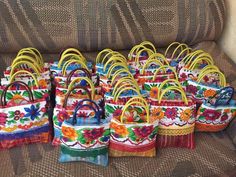 many colorful bags sitting on top of a couch next to each other, all decorated in different colors and patterns