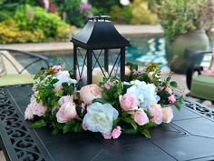 an arrangement of flowers on a table near a pool