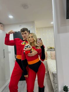 a man and woman dressed in costumes taking a selfie while standing next to each other