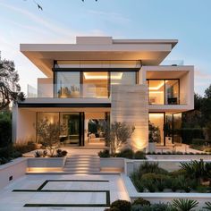 an exterior view of a modern house with landscaping in the foreground and stairs leading up to it