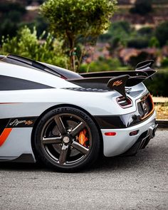 a white and orange sports car parked on the street