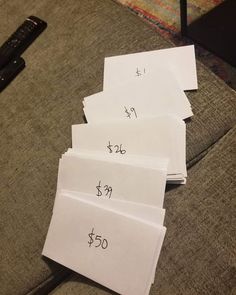 four sheets of paper with numbers on them sitting on a couch next to a remote control