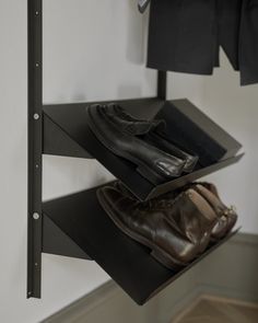 a pair of shoes is sitting on top of a shelf in front of a coat rack