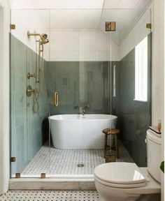 a white bath tub sitting inside of a bathroom next to a toilet and shower head