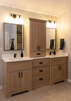 a bathroom with two sinks and large mirrors