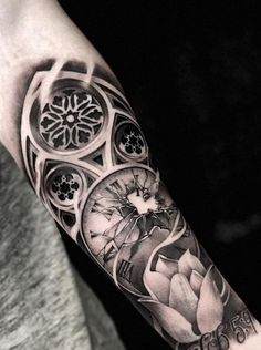 a man's arm with a clock and flowers tattoo on the left side of his arm