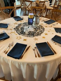 the table is set with silverware and blue napkins