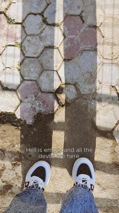 a person standing in front of a brick wall with his shadow on the ground and words above them