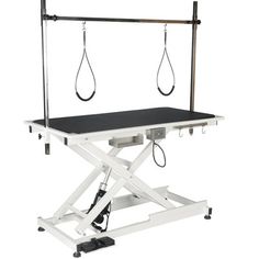 a white table with black top and two hanging cords on it's back end