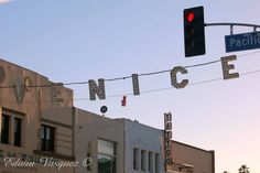 a traffic light hanging from the side of a building next to a sign that reads pacific avenue