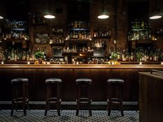 a dimly lit bar with stools in front of it