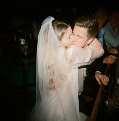 the bride and groom are kissing each other