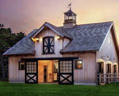 a barn with an open front door and a steeple on the top of it