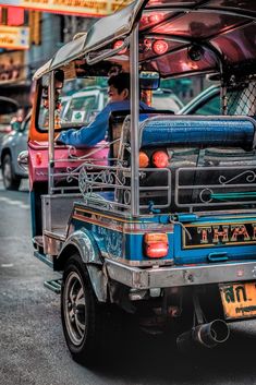 the back end of a vehicle with luggage strapped to it's passenger seat, on a city street