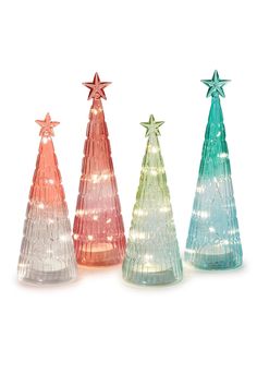 three glass christmas trees with lights on each one and star decorations on the top, all in different colors