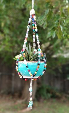 a hanging planter filled with plants and beads