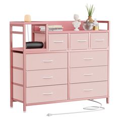 a pink dresser with several drawers and a plant on top