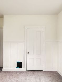 an empty room with white walls and carpet