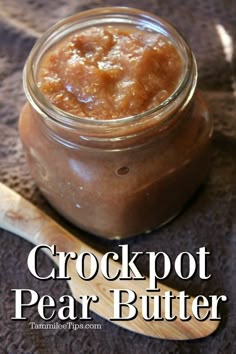 crockpot pear butter in a glass jar with a wooden spoon next to it