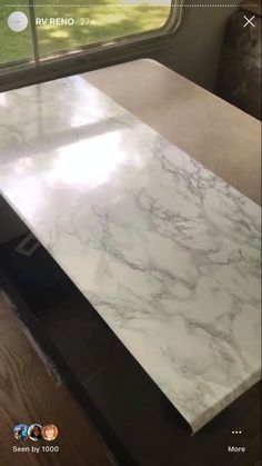 a white marble table top sitting in front of a window