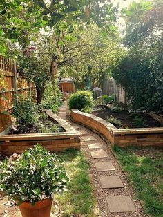 an outdoor garden with wooden planters and stone steps leading up to the back yard