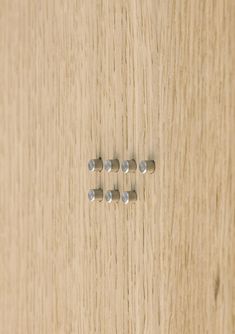 four screws are placed in the middle of a wooden surface