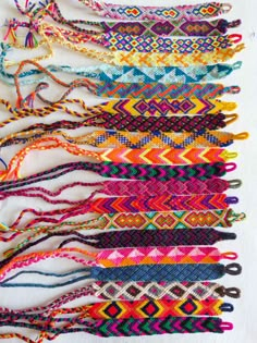 the colorful bracelets are lined up in rows and ready to be woven into each other