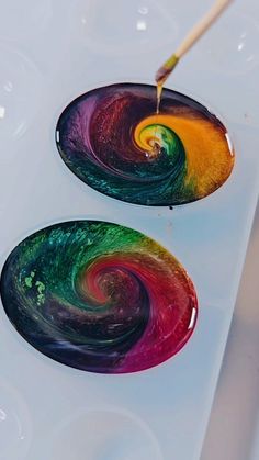 two plates with different colors on them are being painted