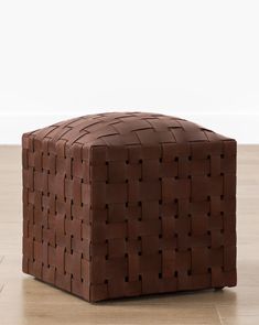 a brown leather ottoman sitting on top of a hard wood floor