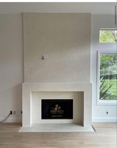 an empty living room with a fire place