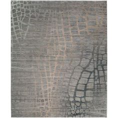 a rug with an abstract design in grey and brown colors on the floor, it is made