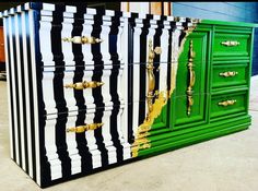 the dresser is painted green, black and white with gold hardware on it's sides