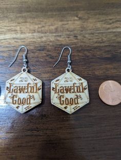 Lawful Good dice earrings. These Lawful Good earrings are made from 1/8 inch birch with the dice features and the alignment engraved into the top. The earrings are double sided so the natural movement of the earring won't matter for visibility of what is on them. The earrings are pictures next to a quarter and a penny for size reference. These earrings are perfect for the gamer geek or 80s show buff who are in love with paper and dice games such as DnD. They are super lightweight so they are com Good Earrings, Lawful Good, Dice Earrings, Earrings Wood, Natural Movement, Dnd Dice, Dice Games, A Penny, Lightweight Earrings