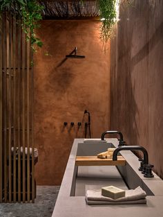 a bathroom with a sink, shower and plants hanging from the ceiling in it's corner