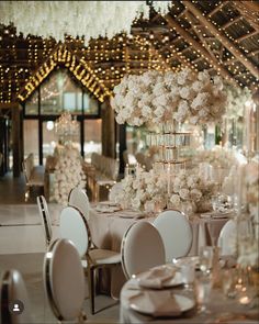 the tables are set with white flowers and candles