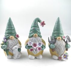 three gnome figurines with flowers on their heads