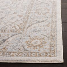 a large rug with an ornate design on the top and bottom in gold, white and grey colors