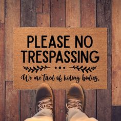 a person standing in front of a door mat that says please no trespassing