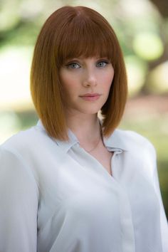 a woman with red hair is smiling at the camera