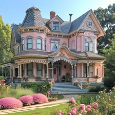 a pink victorian style house with lots of flowers