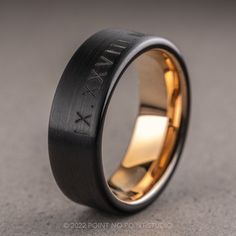 a black and gold wedding ring with the word wax on it