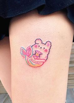 a small winnie the pooh tattoo on the thigh