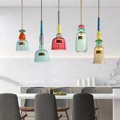 five colorful glass pendants hanging from the ceiling above a dining room table and chairs