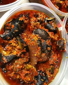 three plastic containers filled with food on top of a white tablecloth covered ground beef and mussels in tomato sauce