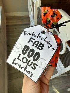 a hand holding a tag that says, thanks for being a fab boo - lous teacher