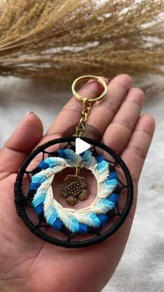 a hand holding a blue and white beaded keychain